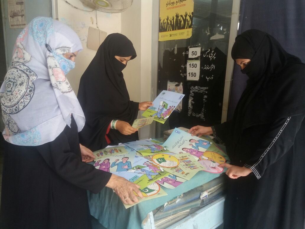 Women reviewing community awareness material
