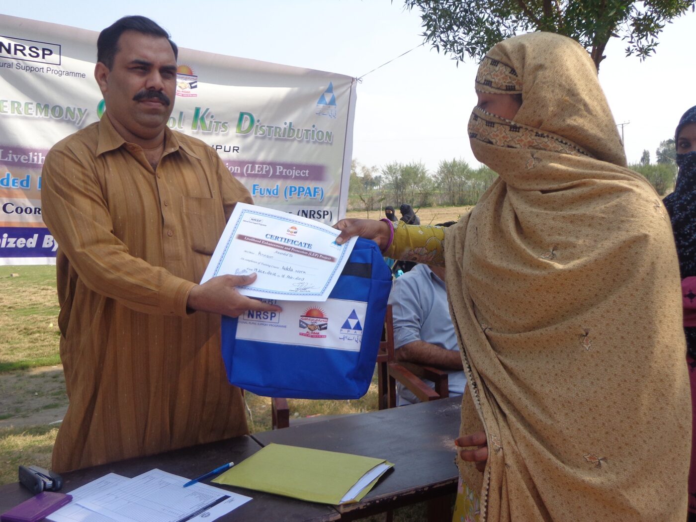 A trainee receiving a certificate and vocational kit