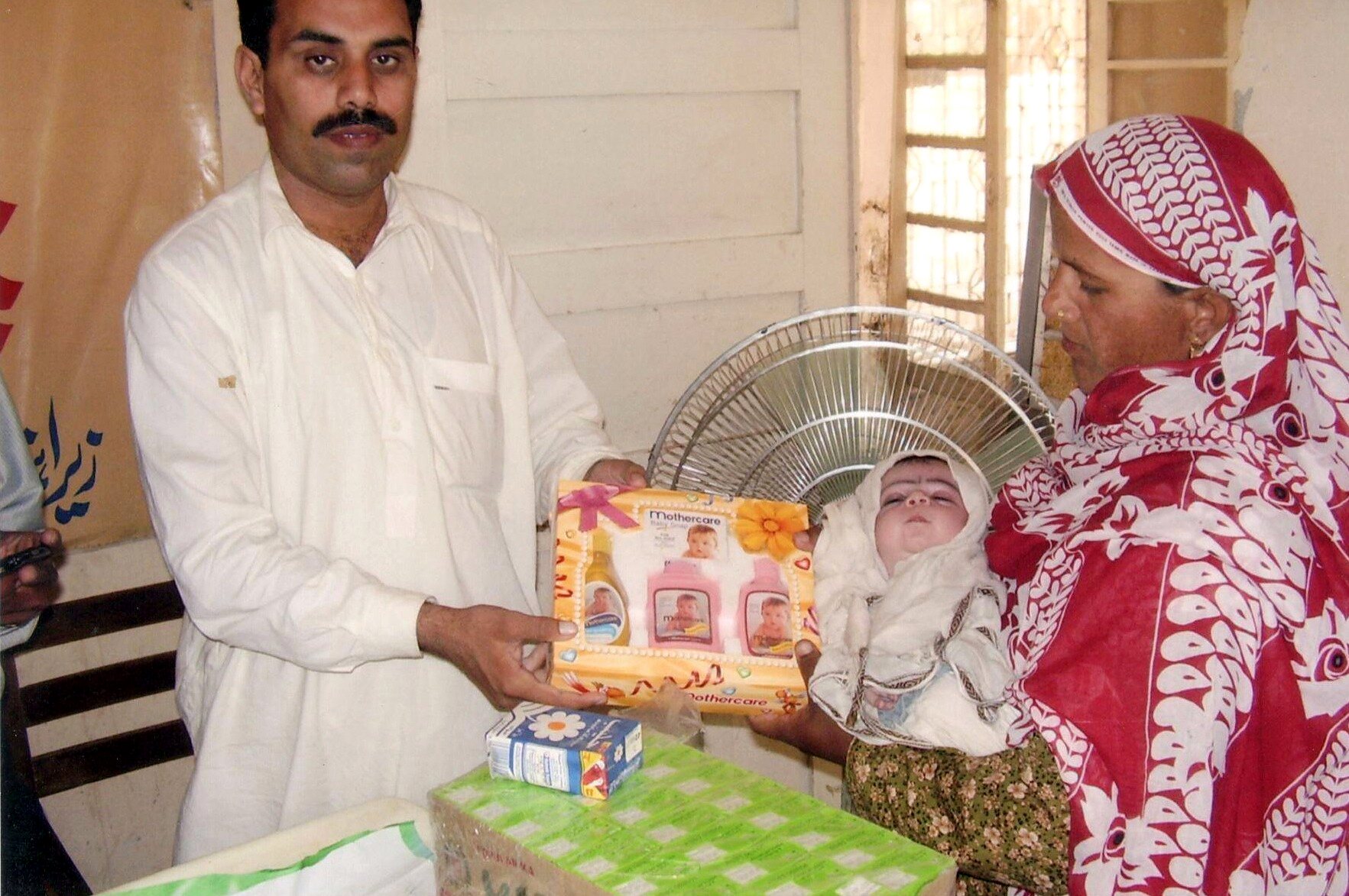 Mother receiving a newborn care package from a health worker